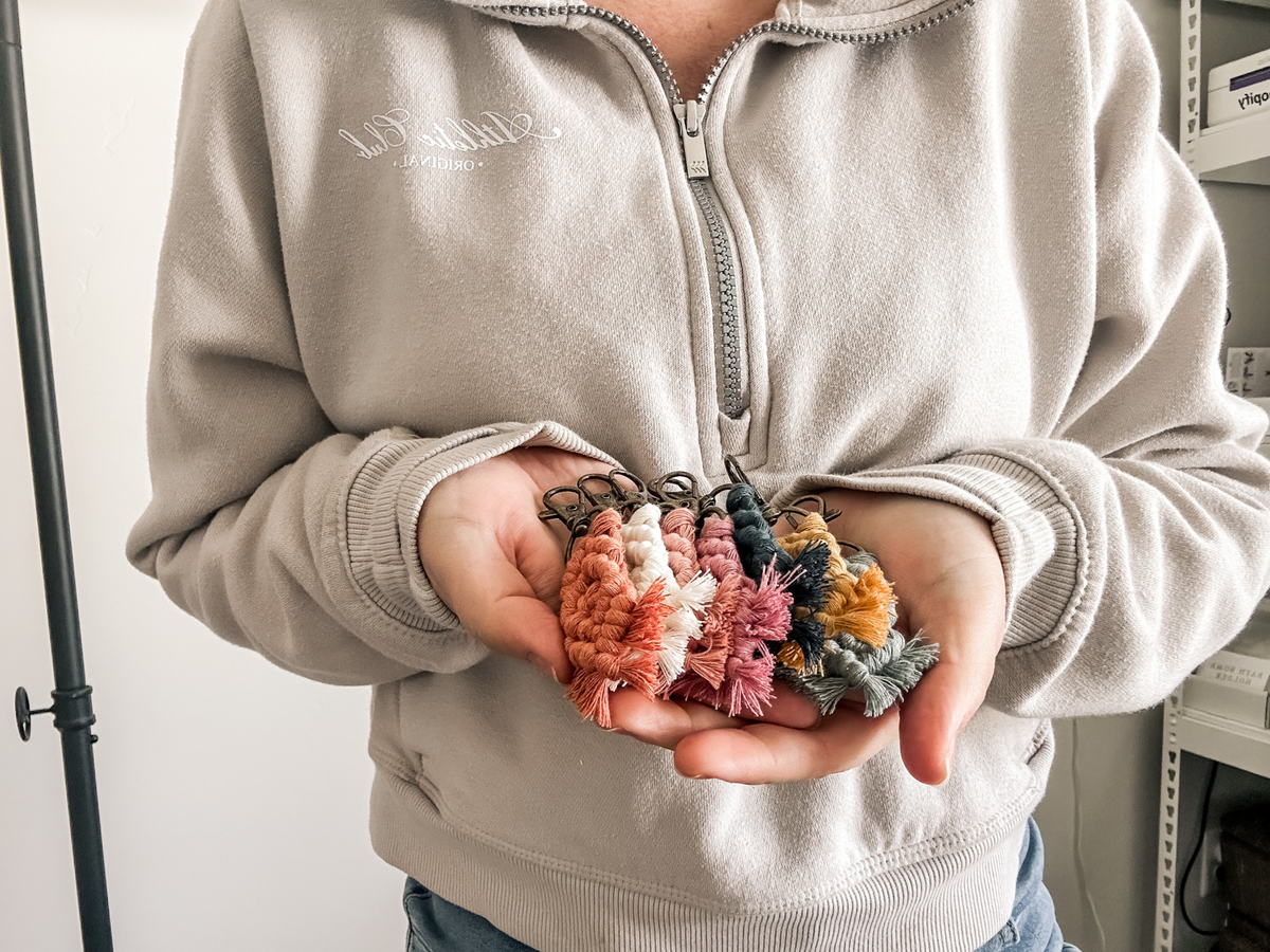 an image of my hands holding all 7 mini macrame keychains.